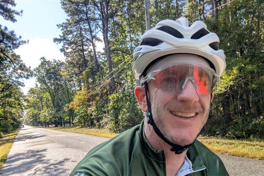 Tim cycling on a tree-lined road